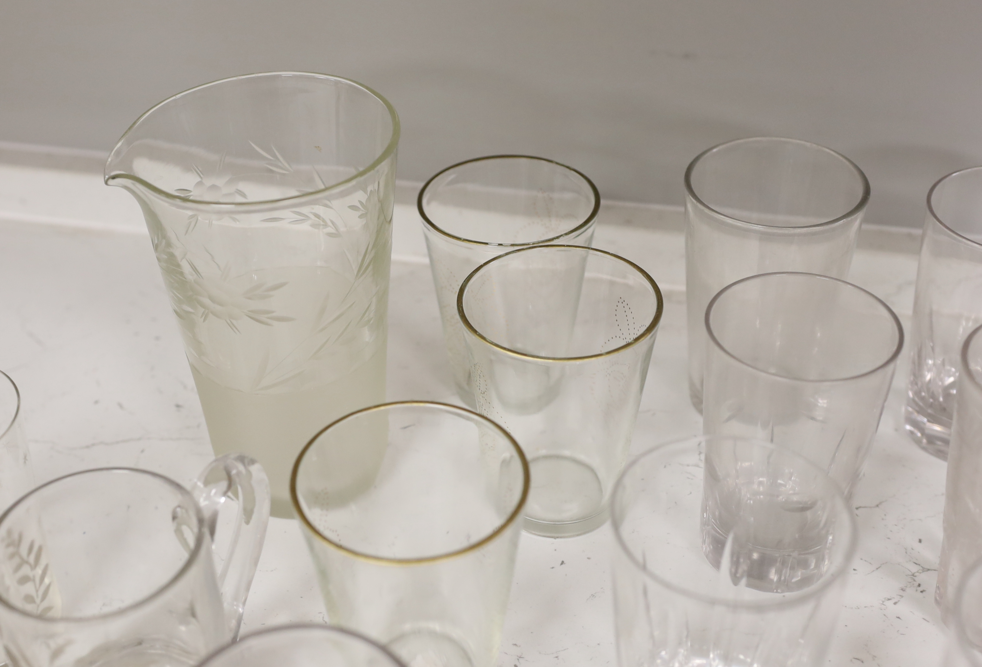 A collection of 19th and early 20th century drinking glasses, including beakers, some etched examples, half pint ale mug, an etched glass jug, etc., tallest 17cm (20)